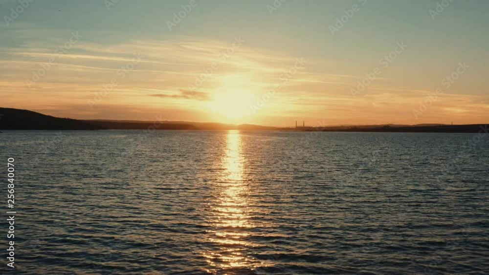 Aerial view slide forward calm surface of sea water with flock of floating seabirds against the backdrop of sunset day and beautiful horizon with clouds in the sky. Drone Aerial view slide forward calm surface of sea water with flock of floating seabirds against the backdrop of sunset day and beautiful horizon with clouds in the sky. Drone