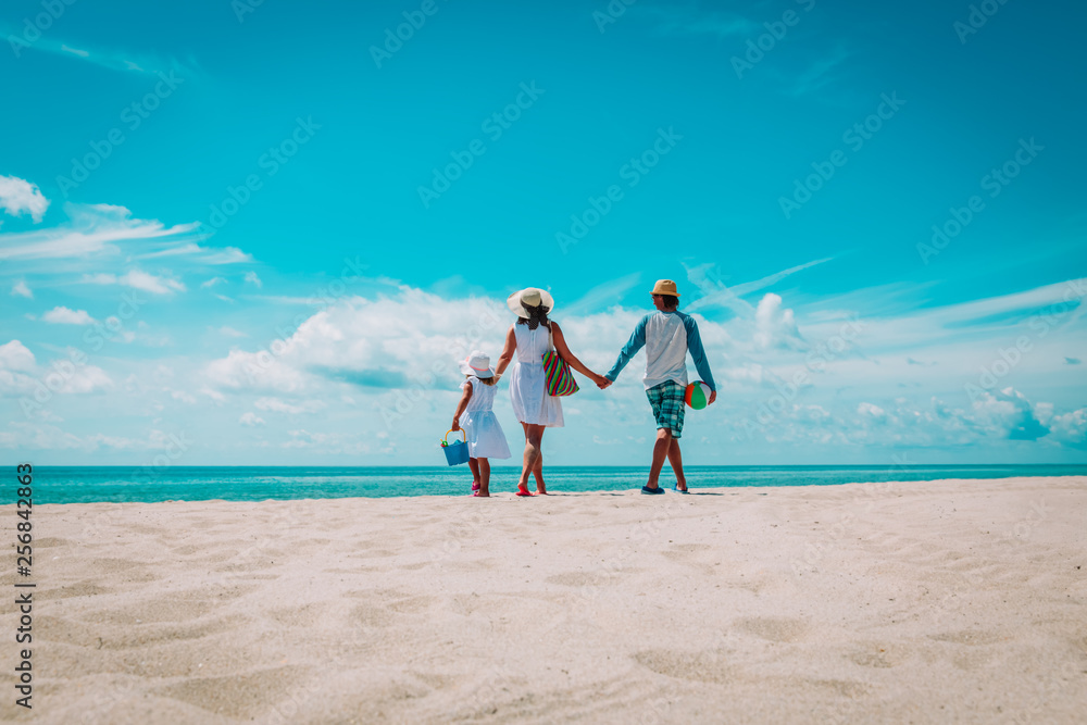 happy family with child walking on tropical beach