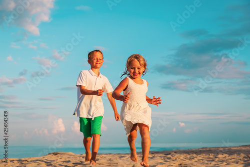 happy little boy and girl running on beach