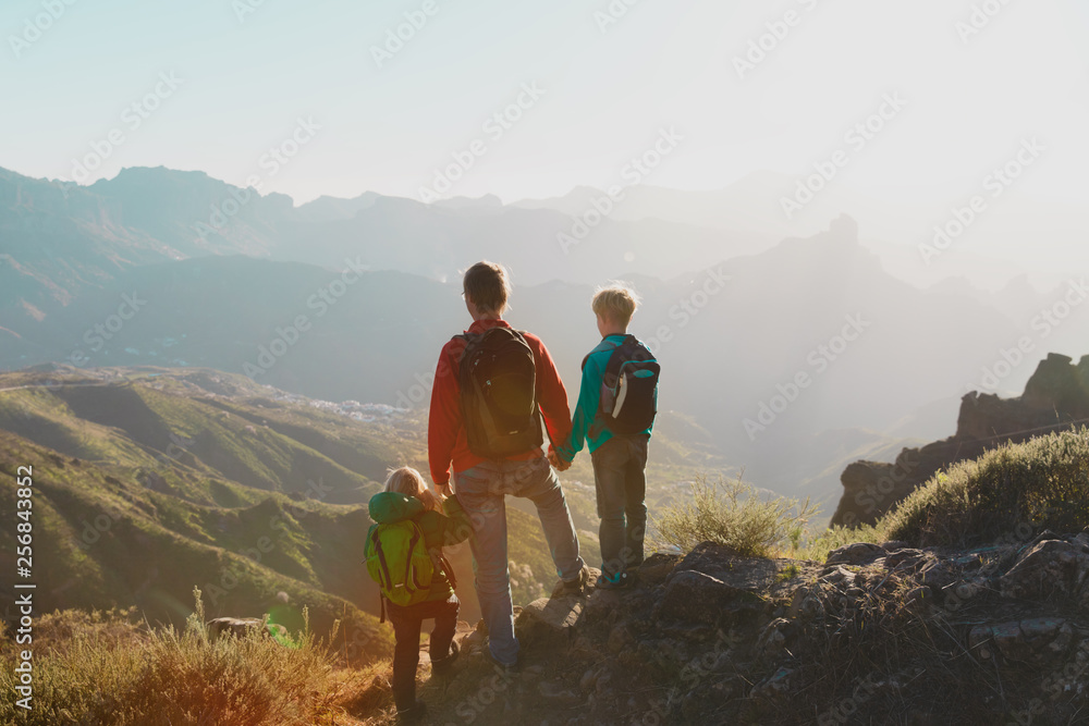 Father with kids travel in sunset mountains