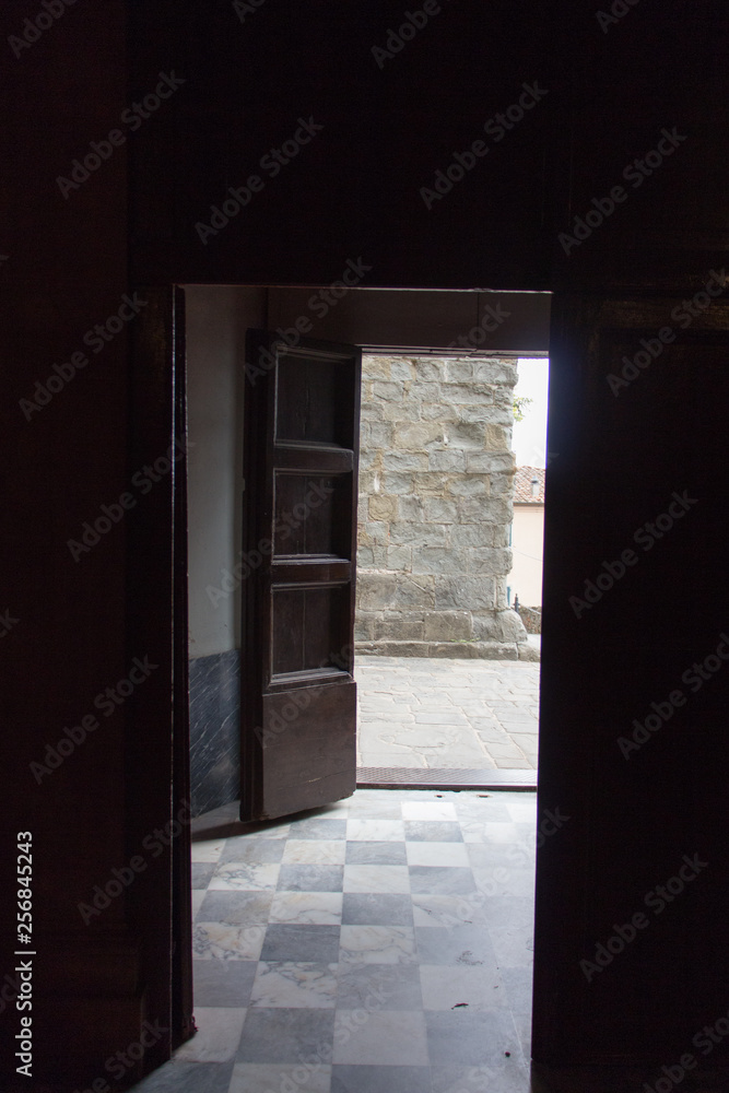 Exit door at the end of a dark ancient room. Exit door at the end of a dark ancient room.