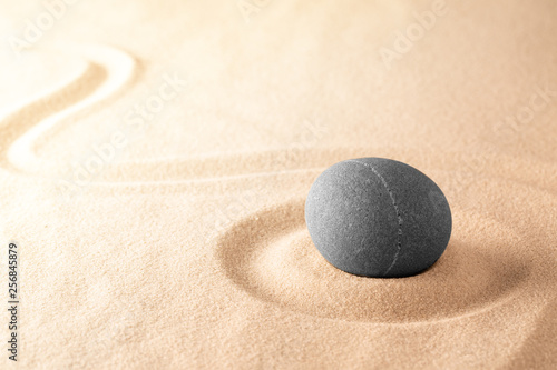 Spa wellness or mindfulness stone and sand garden. Concentration or focus point for spiritual balance and purity of mind and soul. Sandy background with copy space. .
