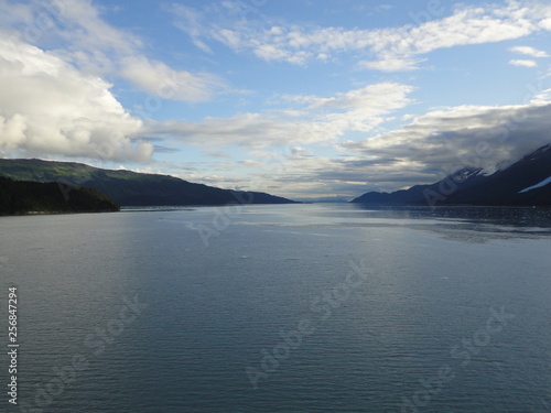 Passage in the Pacific Ocean between two mountain ranges. Calm peaceful waters flowing slowly under a cloudy sky.