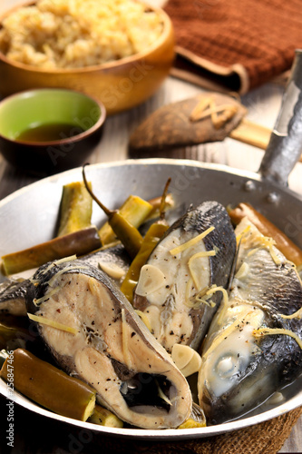 Fish stew on white plate with rice. Paksiw na Bangus. Filipino cuisine