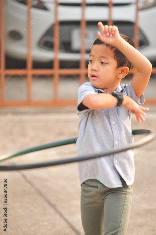 Boy and girl playing hula hoop on the street in town Boy and girl playing hula hoop on the street in town