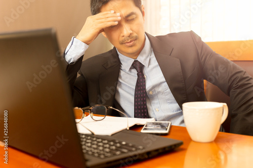 Businessman leaning with hand on his head on eyes closed feeling sleepy.