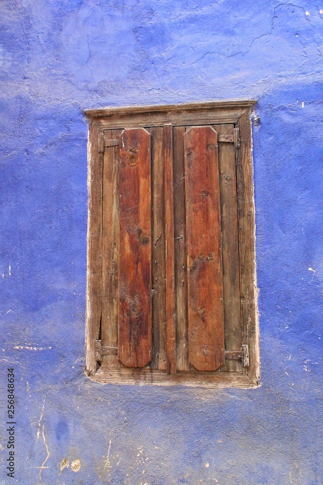 An old wooden door on the blue wall An old wooden door on the blue wall