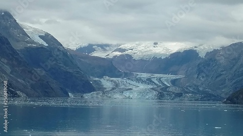 Glaciers within Glacier Bay National Park in Alaska. Glaciers coming over mountain peaks and sliding into the Pacific Ocean