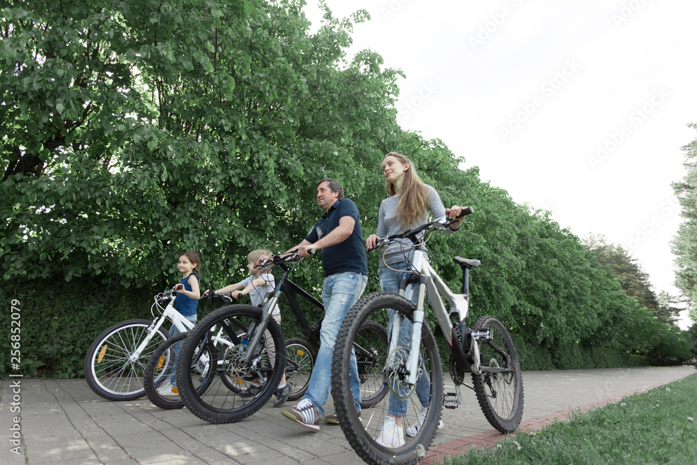 happy family walking with bicycles in the city Park. happy family walking with bicycles in the city Park.