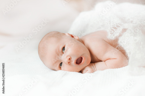 surprised newborn babe lying on the bed. © yurolaitsalbert