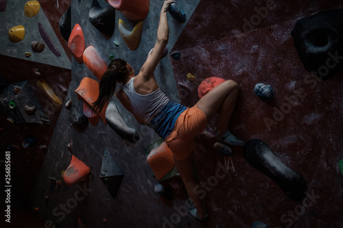 Athletic woman practicing in a bouldering gym