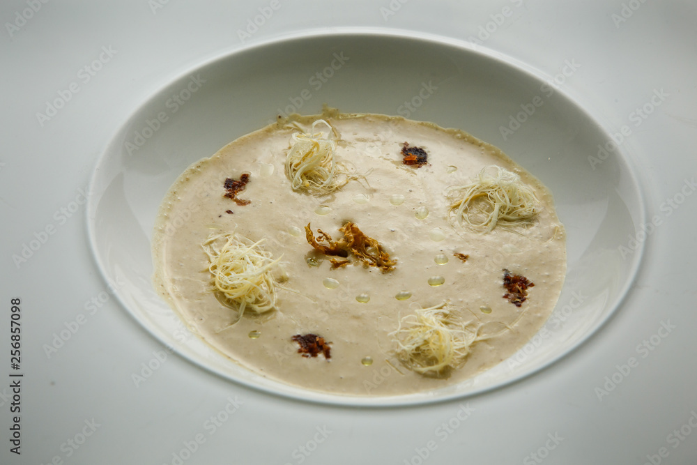 closeup seafood cream soup decorated with dried squid and soy sauce closeup seafood cream soup decorated with dried squid and soy sauce