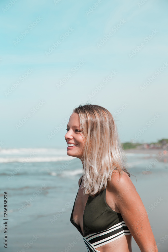 Beautiful caucasian woman in green bikini on tropical beach.