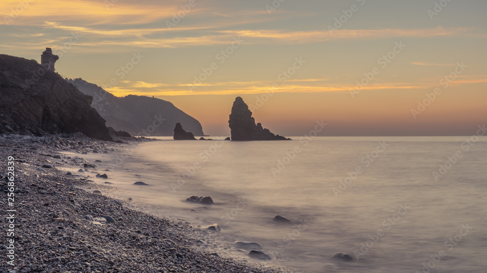 Nerja, Malaga, Andalusi, Spain - February 10, 2019: Playa del Molino, small stone beach with three large rocks on the shore, Nerja, southern Spain