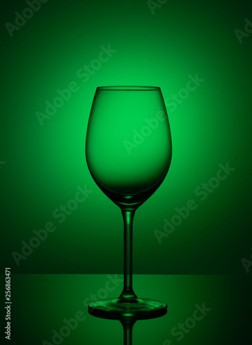Empty wine glass is on acrylic glass, on a green background