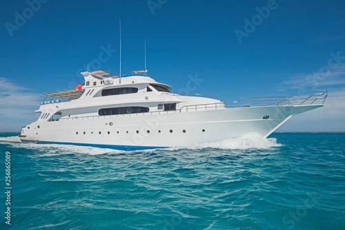Luxury motor yacht sailing out on tropcial sea photo