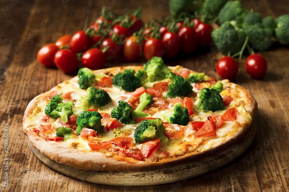Vegetarische Pizza mit Brokkoli, frischen Tomaten und Sauce Hollandaise
