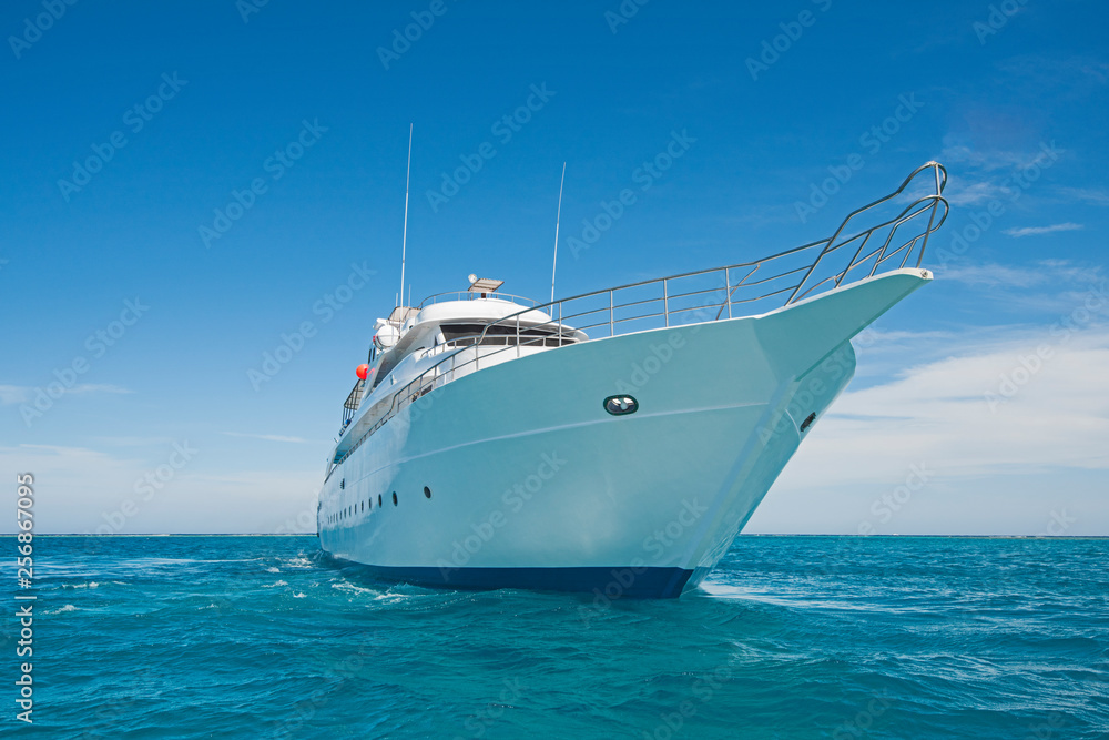 Luxury motor yacht sailing out on tropcial sea