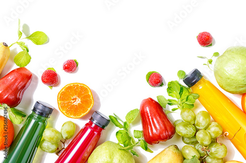 Beautiful colorful juice bottles with tropical fruits border isolated on white background. Vegetarion food concept. Detox. Text space photo