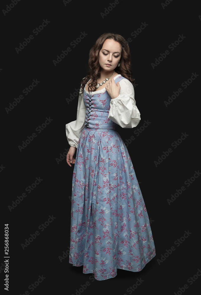 Young beautiful woman in long medieval dress on dark Young beautiful woman in long medieval dress on dark