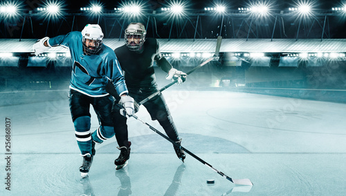 Ice Hockey Arena. Two players competition in the helmet and gloves on stadium with stick and puck.