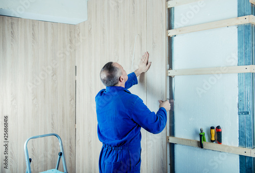 male builder revets wood panels for a facade of walls