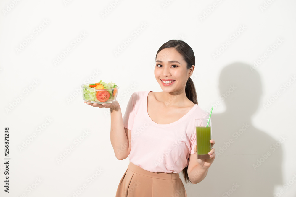 Woman with green detox smoothies, salad in glass bowl isolated on white background. Proper nutrition, vegetarian food, healthy lifestyle, dieting concept. Area to copy space Woman with green detox smoothies, salad in glass bowl isolated on white background. Proper nutrition, vegetarian food, healthy lifestyle, dieting concept. Area to copy space