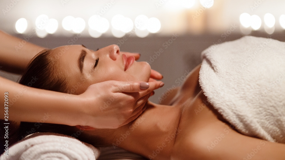 Face massage. Young woman getting spa treatment
