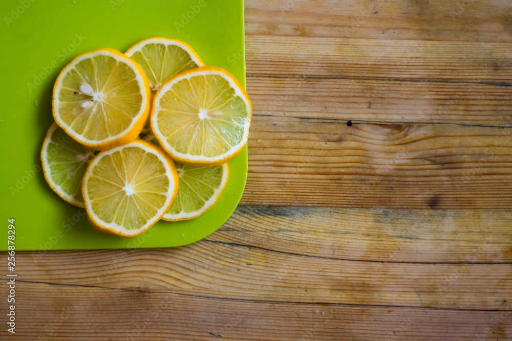 Wooden table with lemon slices on a cutting board. Wooden table with lemon slices on a cutting board.