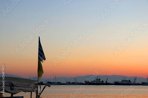 Fishing boats at sunset. View of the Greek and the Byzantine flag, Nea Michaniona port, Thessaloniki, Greece.  photo