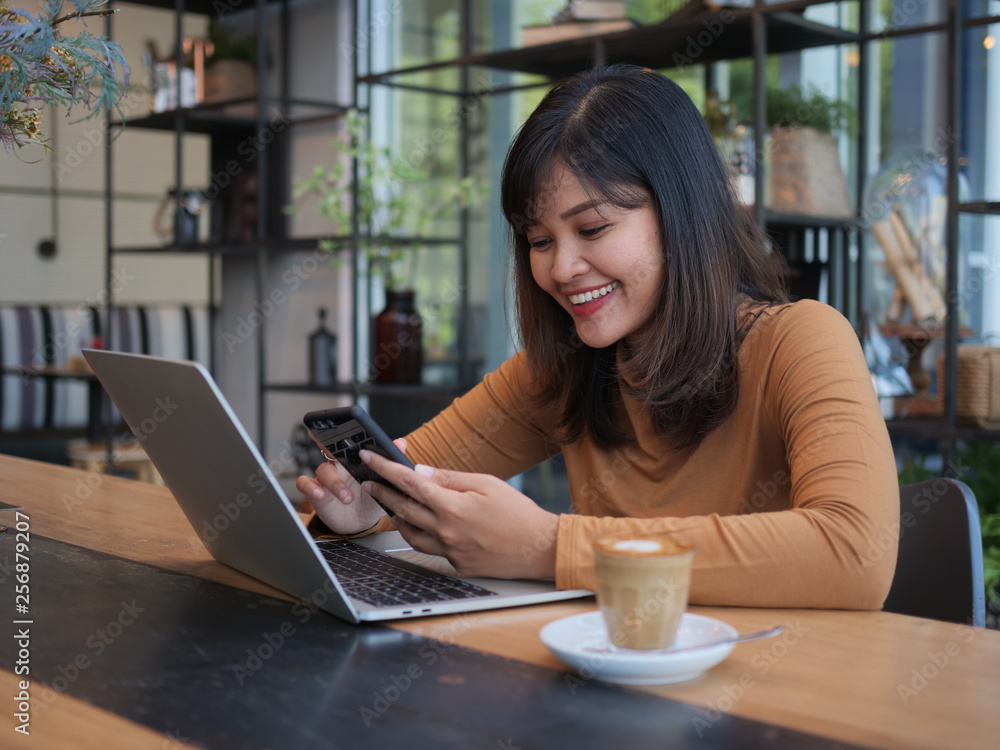 Fototapeta premium Asian woman using laptop in coffee shop cafe