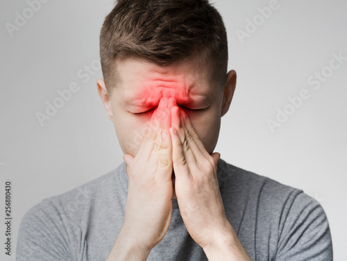 Sad man holding his nose because sinus pain photo