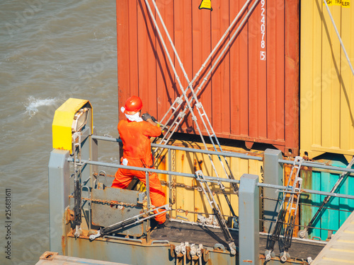 Slika na platnu Deck worker on the vessel hold on containers.