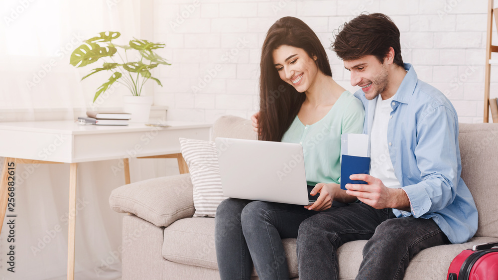 Planning tour. Happy couple using laptop at home Planning tour. Happy couple using laptop at home