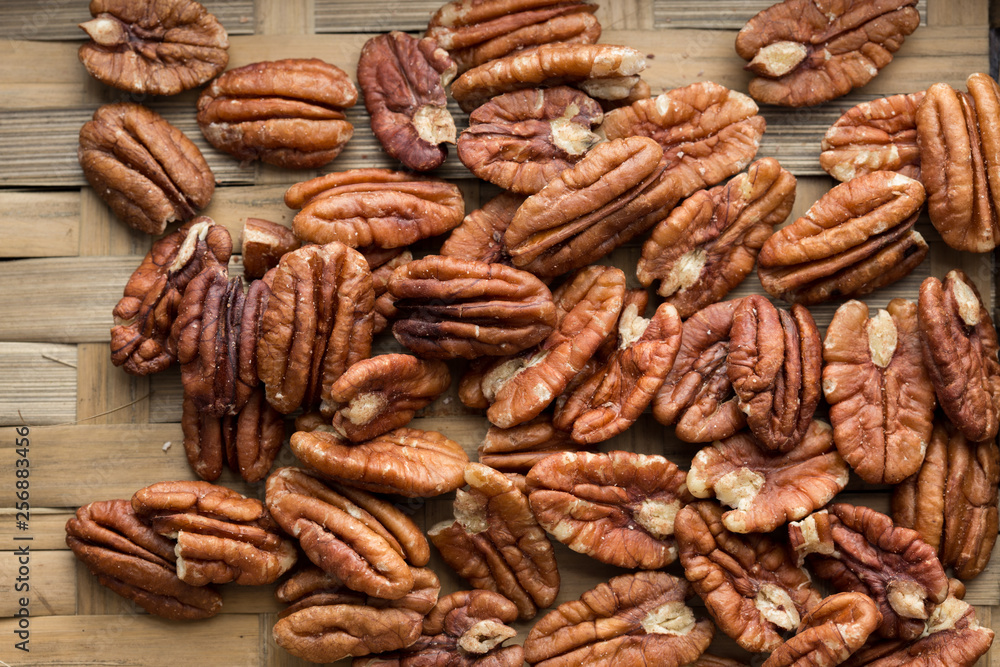 Pecan nuts on a rustic wooden table and pecan nuts in bowl. Pecan nuts on a rustic wooden table and pecan nuts in bowl.