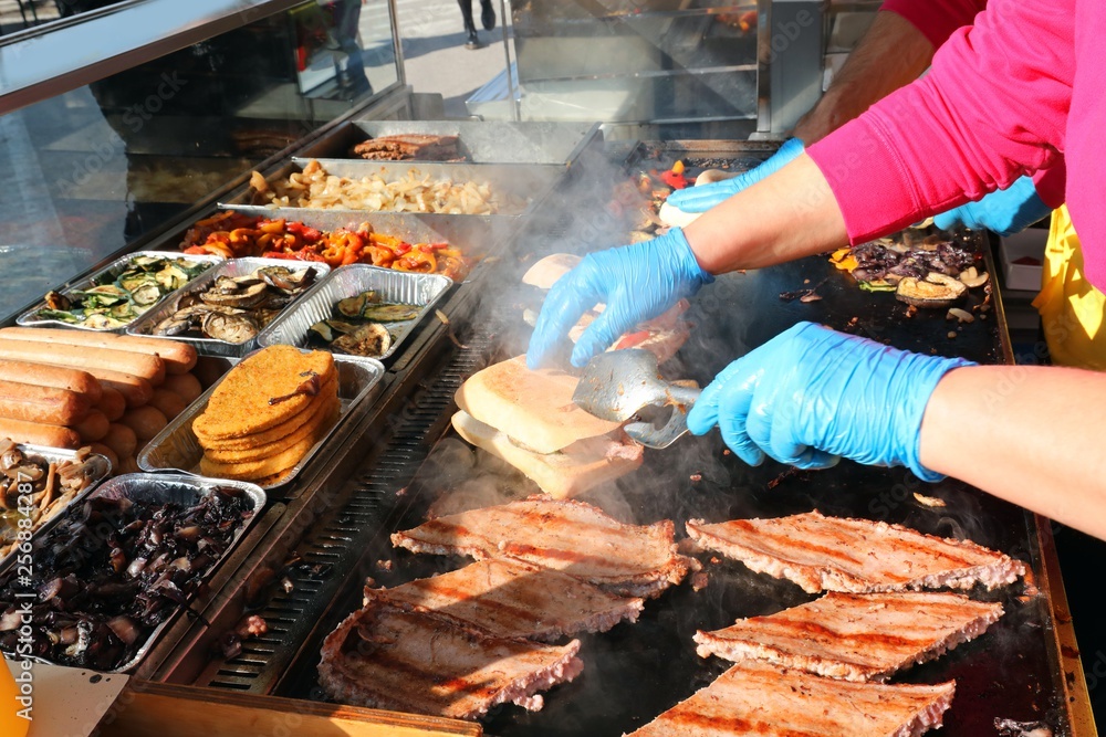 chef with gloves and cooked sausages in the hot plate chef with gloves and cooked sausages in the hot plate