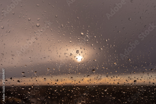 Rain drops on the window in the light of eve sun