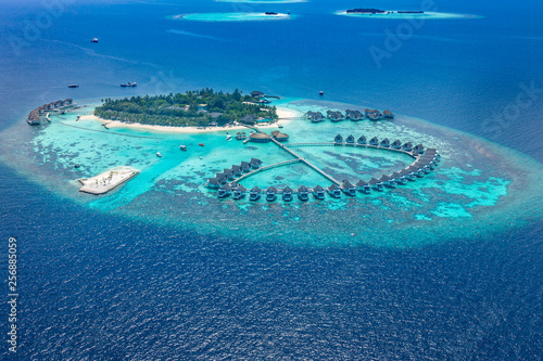 Luxury resort island in Maldives with water bungalow background and blue sea sky aerial view 