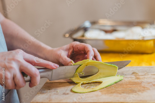 Close up of senior woman hands cutting baguette - making sandwich bruschetta - home cooking
