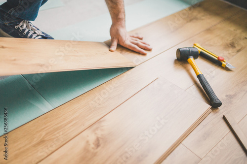 Fotografi Professional flooring installation - laying a new laminate with a wooden pattern