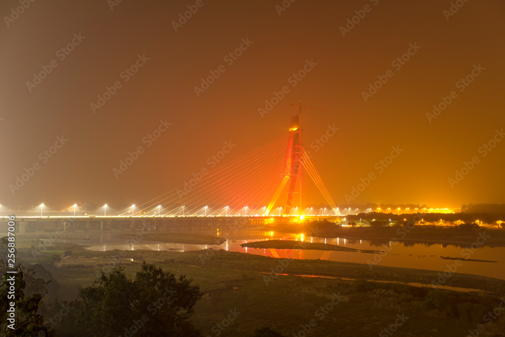 Obraz premium cable-stayed bridge illuminated across the Yamuna River at night. Signature Bridge. Delhi india