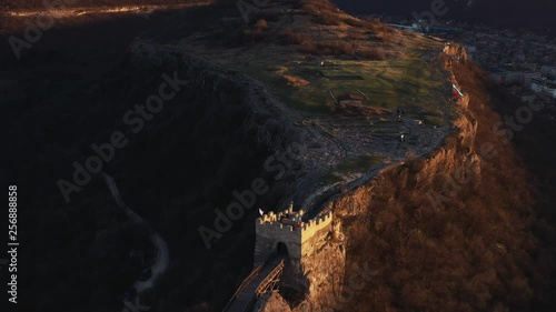 Ovech Fortress, Provadia, Bulgaria. Drone up from a height of air on a bridge on top of a rock and the remains of an ancient fortress in early spring in the light of the sunset of a sunny day. Sun ray photo