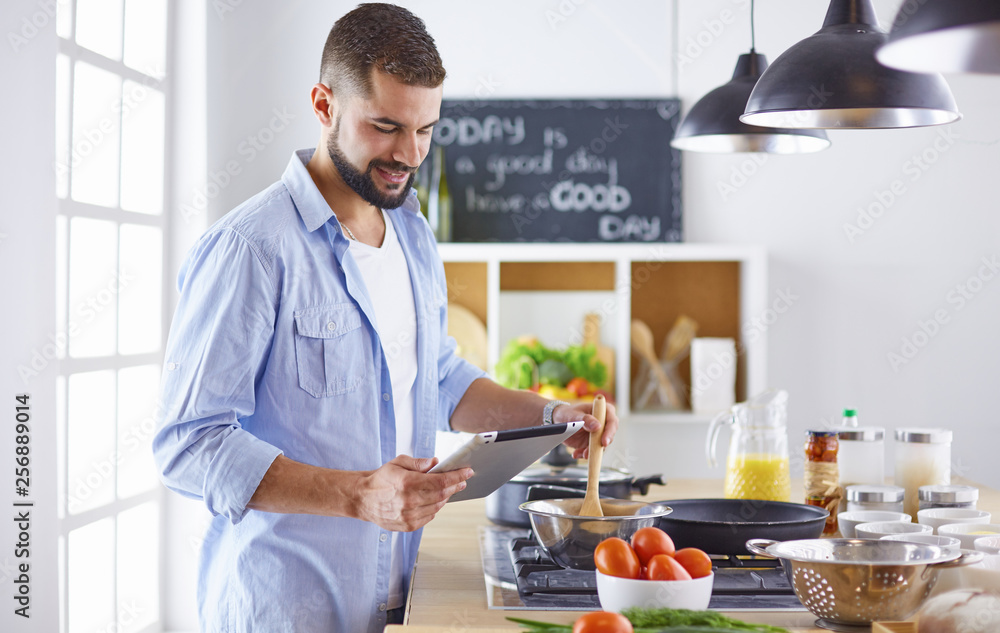 Smiling and confident chef standing in large kitchen Smiling and confident chef standing in large kitchen