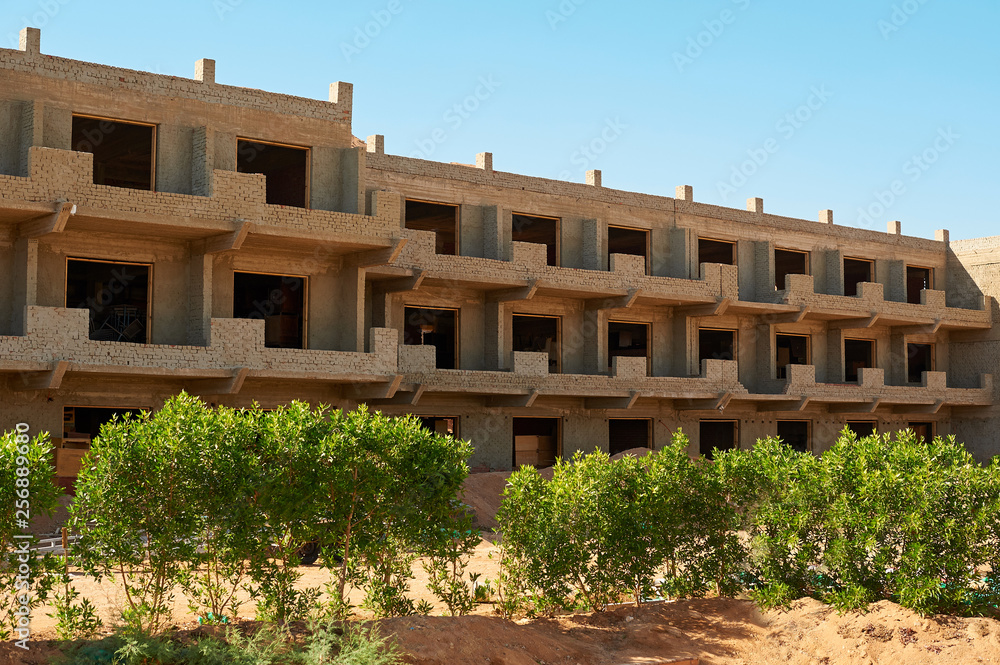 Construction of new modern residential building, workers pour concrete in wooden framework