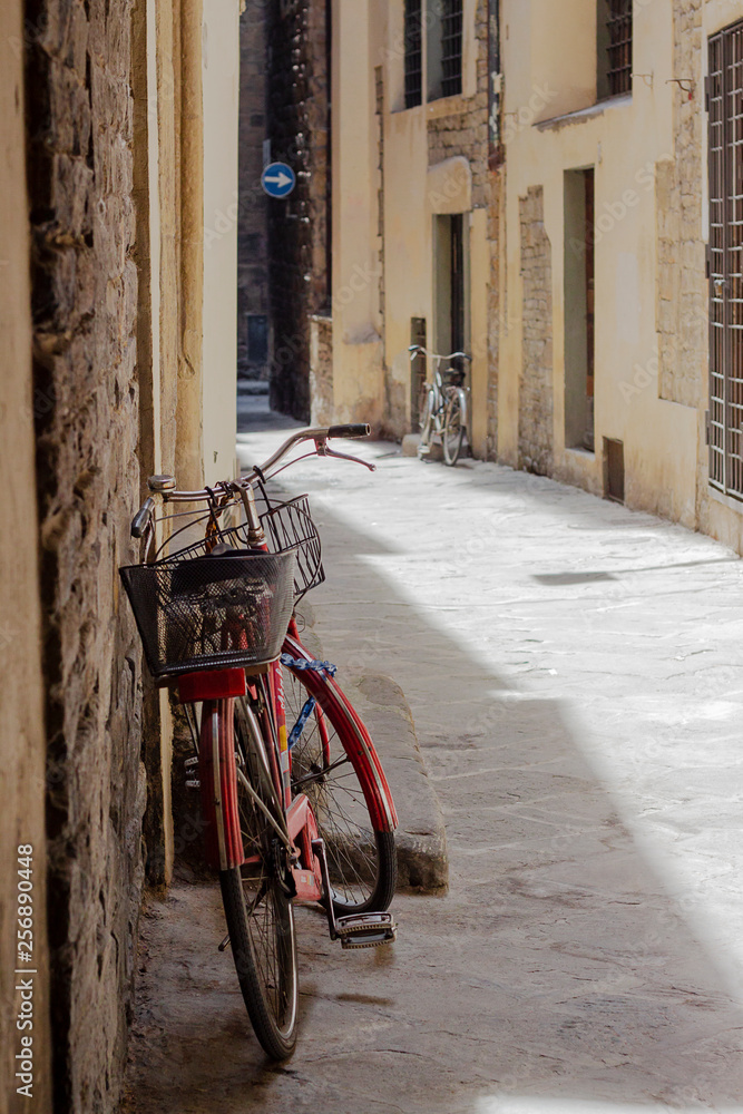 Red bike on a narrow street in the old town. Italy, Florence