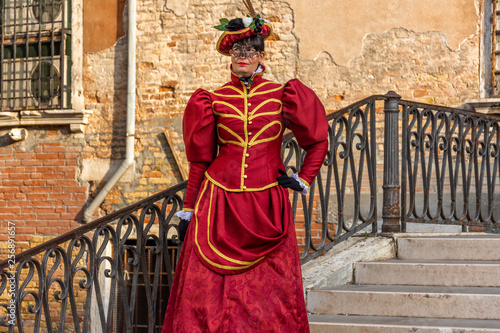 taly, Venice, 2019, carnival, people with beautiful masks walk around Piazza San Marco, in the streets and canals of the city, posing for photographers and tourists, with colorful clothes.