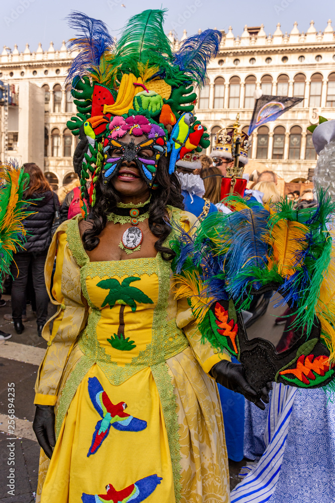 Italy, Venice, 2019, carnival, people with beautiful masks walk around Piazza San Marco, in the streets and canals of the city, posing for photographers and tourists, with colorful clothes.