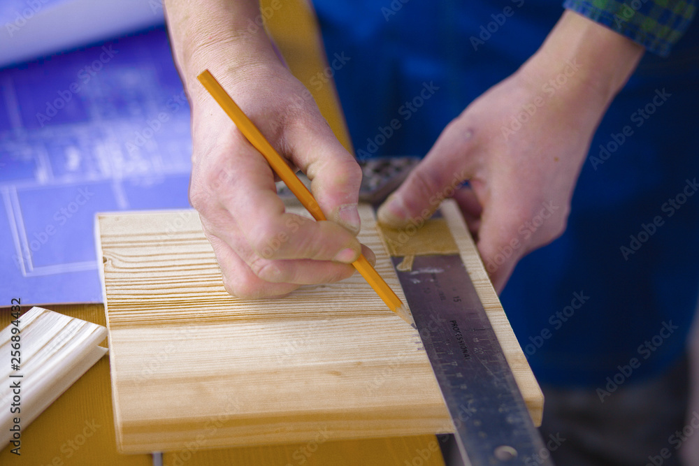 Engineer carpenter working on laptop and sketching project Engineer carpenter working on laptop and sketching project