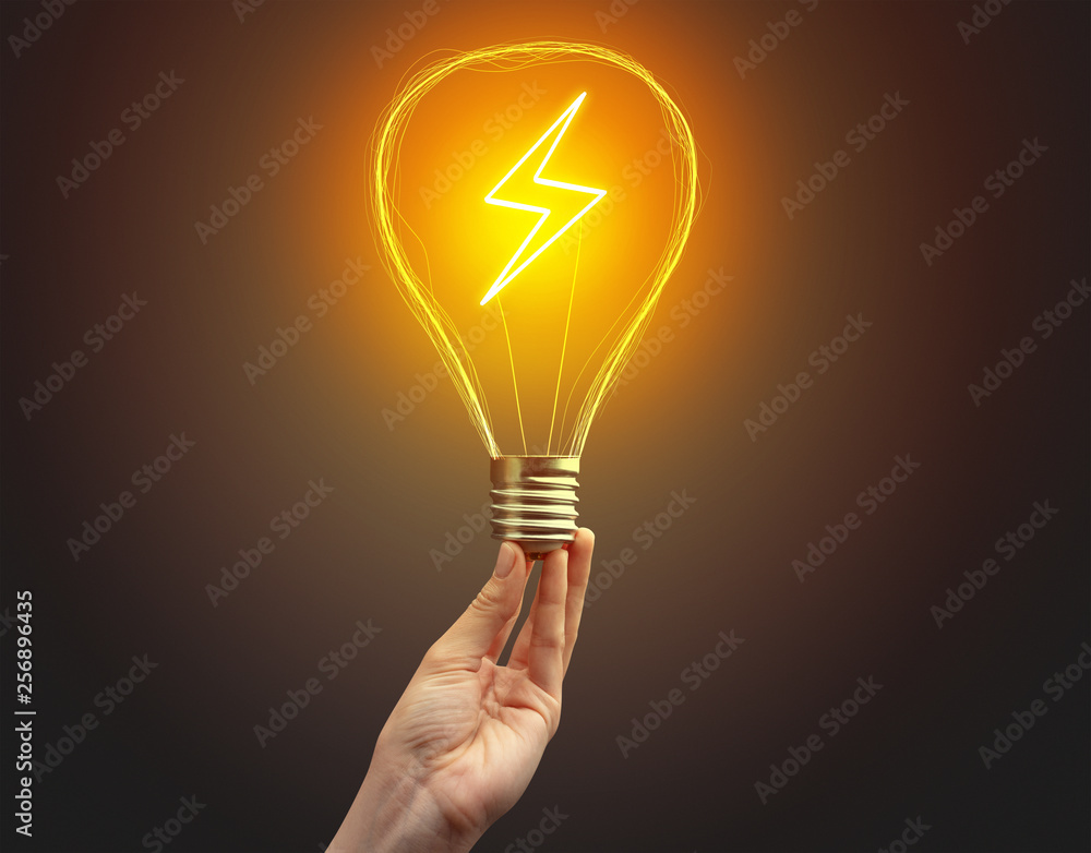 Hand holding light bulb on dark background. New Eco idea concept Hand holding light bulb on dark background. New Eco idea concept