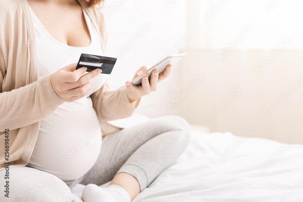 Mother shopping online with smartphone and credit card